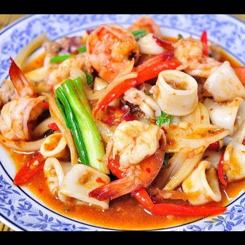 Plated dish of seafood with red sauce on a decorative plate